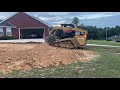 Caterpillar 279d pushing and grading dirt