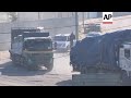 Aid trucks enter Gaza through the Rafah crossing, escorted by Hamas police