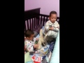 Twin boy playing in crib before bedtime