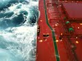Capesize bulk carrier on heavy seas at Pacific Ocean.