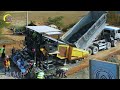 Amazing road construction site progressing with gravel trucks laying down gravel on a paver machine