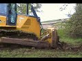 John Deere 850J pushing trees