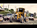 Wonderful road machines work together to spread a gravel new road in the process of being compacted