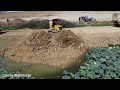 Dump trucks 10Ton open work stone soil into the lake process with KOMATSU D31P Dozer push & Clear
