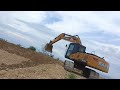 excavator sany sy215c working selop dasar kemiringan tanggul tambak di atas gunung